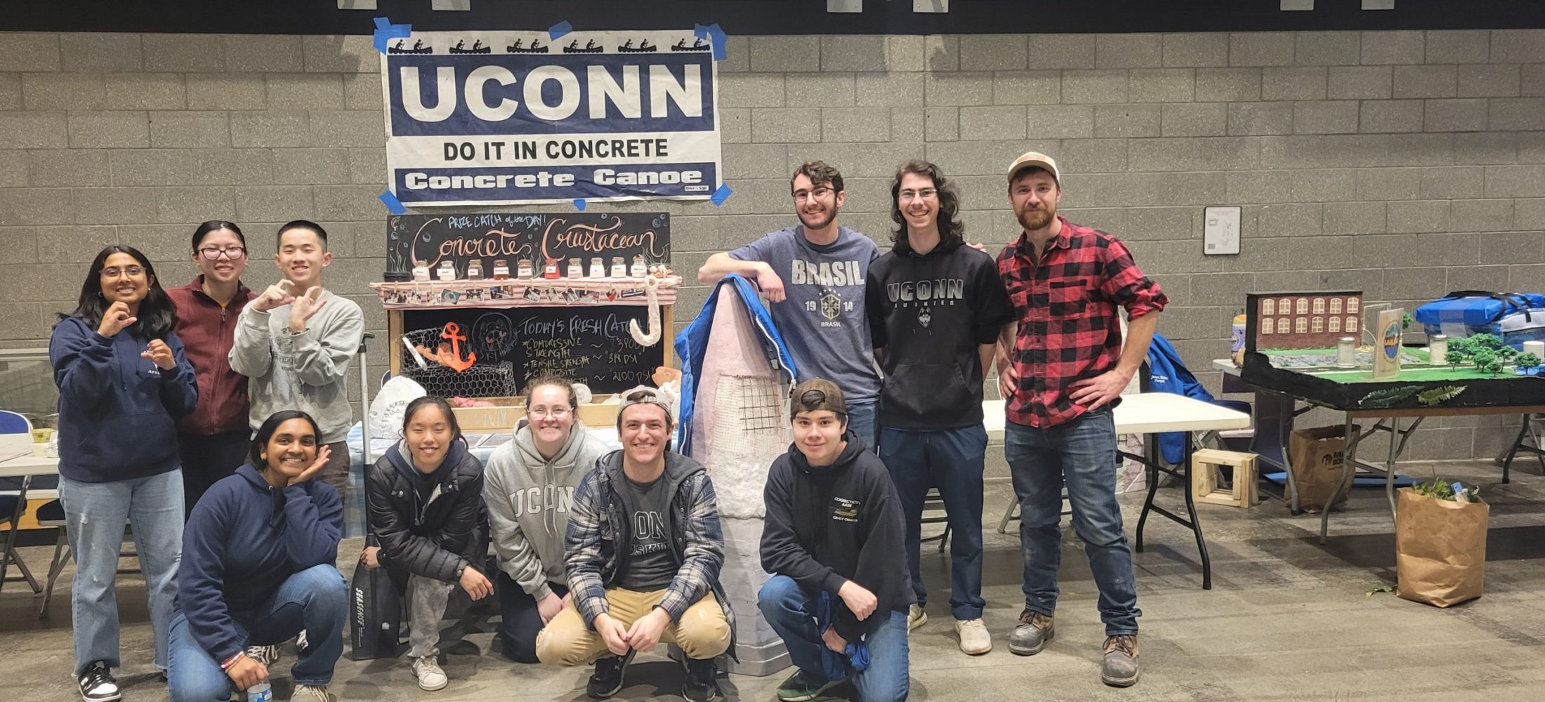 the team smiling and posed in front of the concrete crustacean display