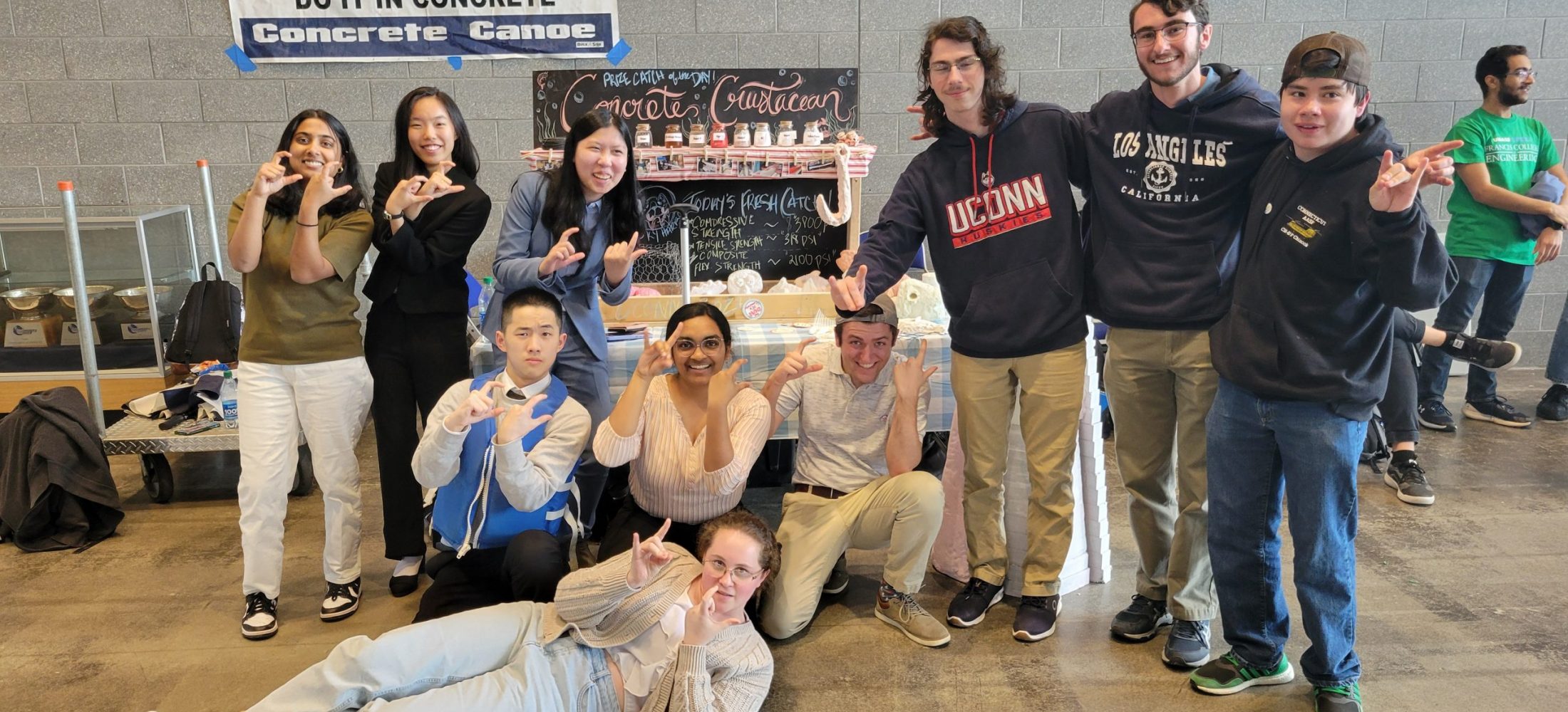 the team posing with crab claws in front of the concrete crustacean display