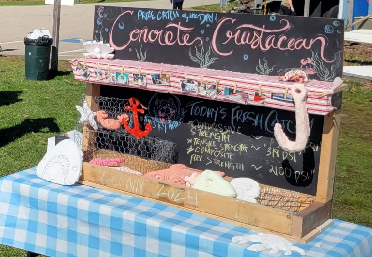 concrete crustacean display that resembles a fish stand with fake lobster traps and a chalkboard displaying information