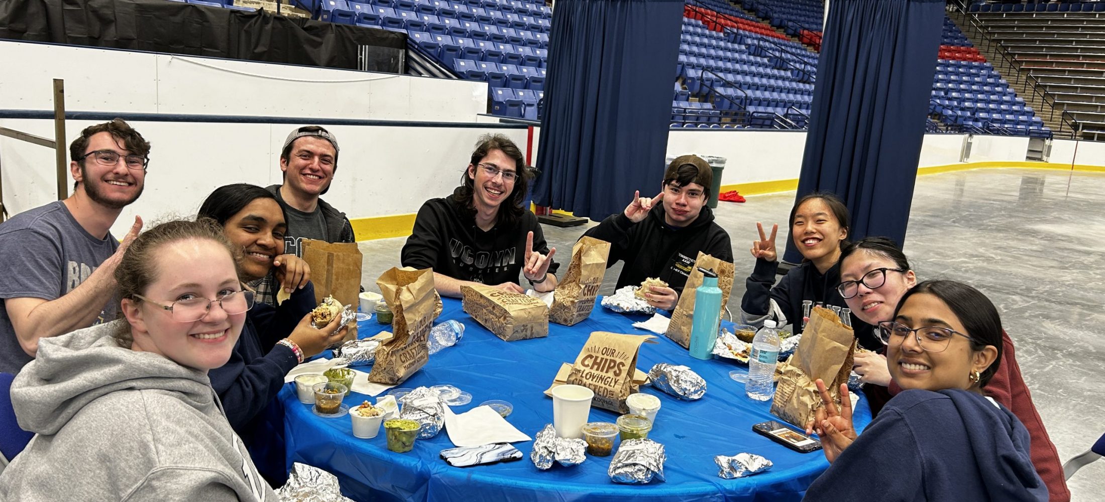 the team enthusiastic at the competition while eating at around a table